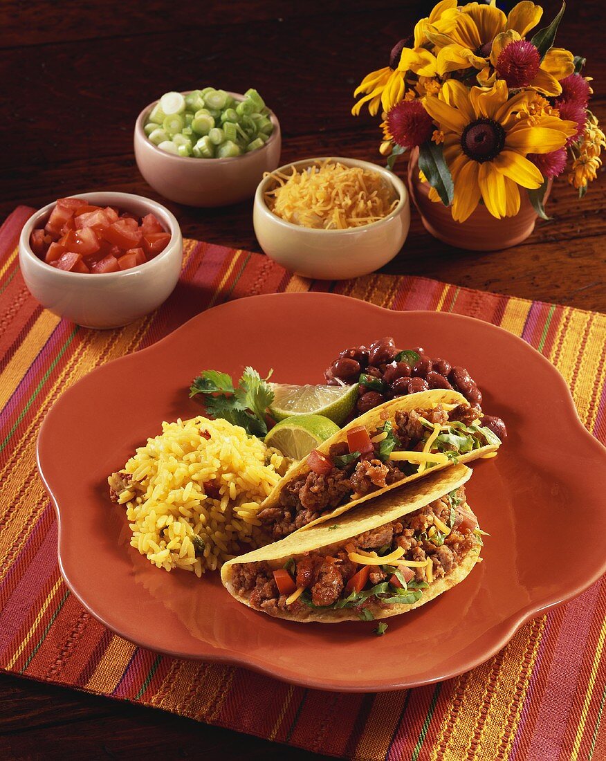 Two Beef Tacos on a Plate with Rice and Beans; Toppings