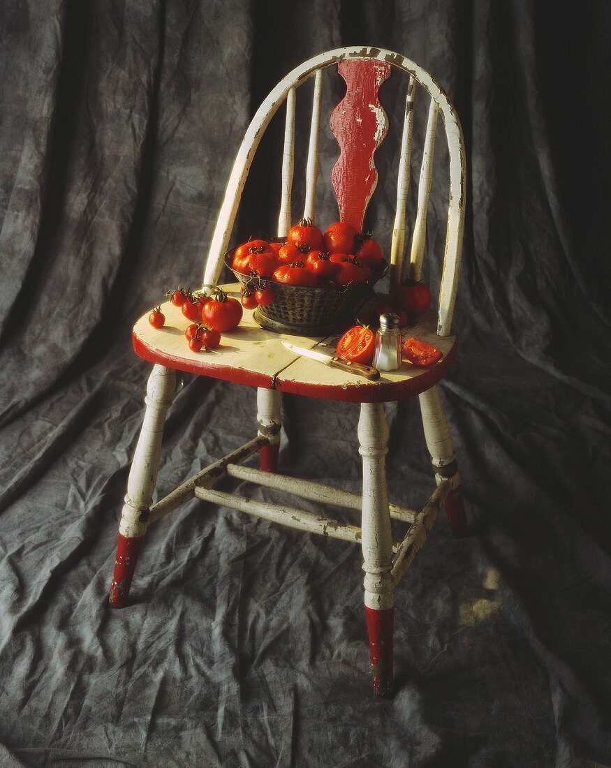Frische Tomaten, teilweise im Korb, auf einem Stuhl