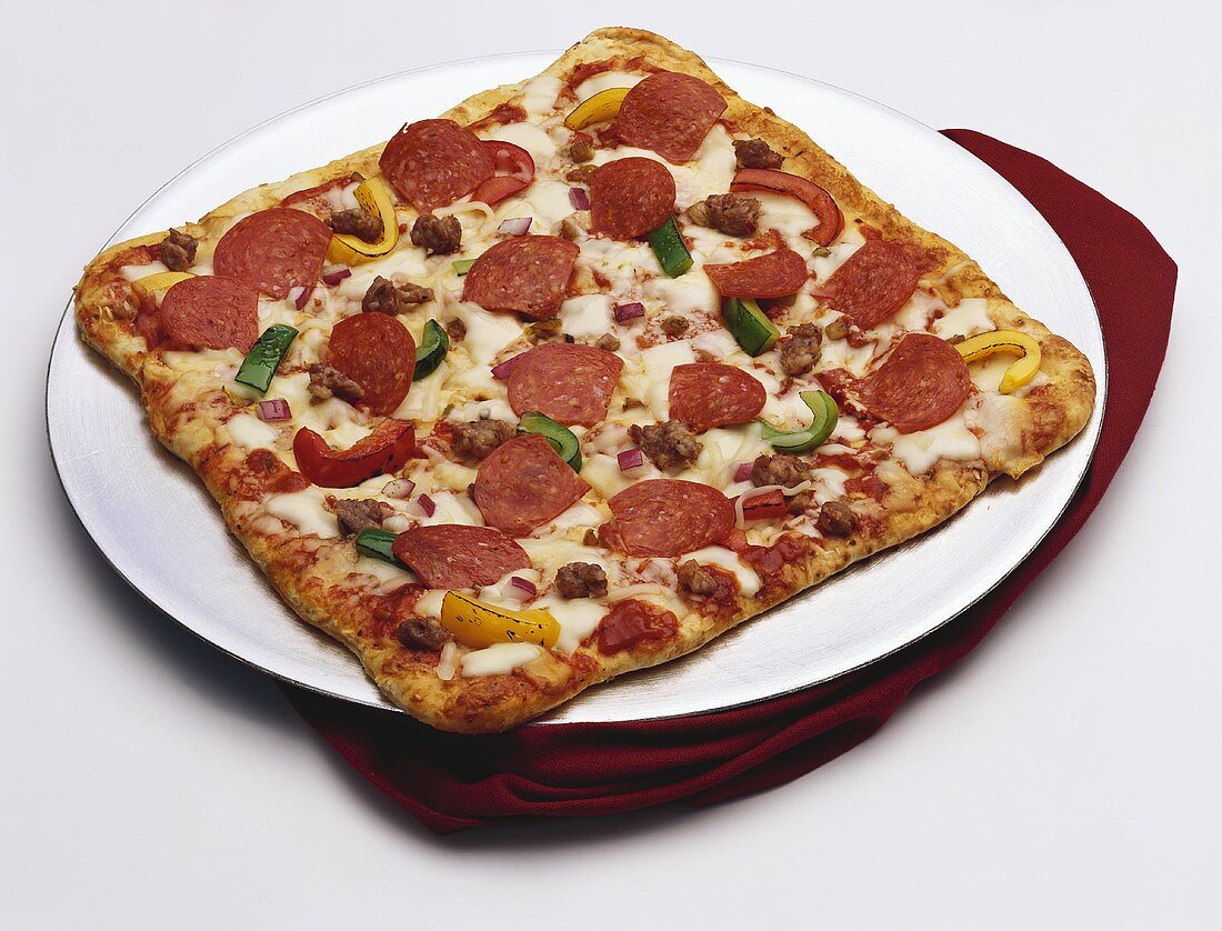 Quadratische Pizza mit Peperoniwurst und Paprika
