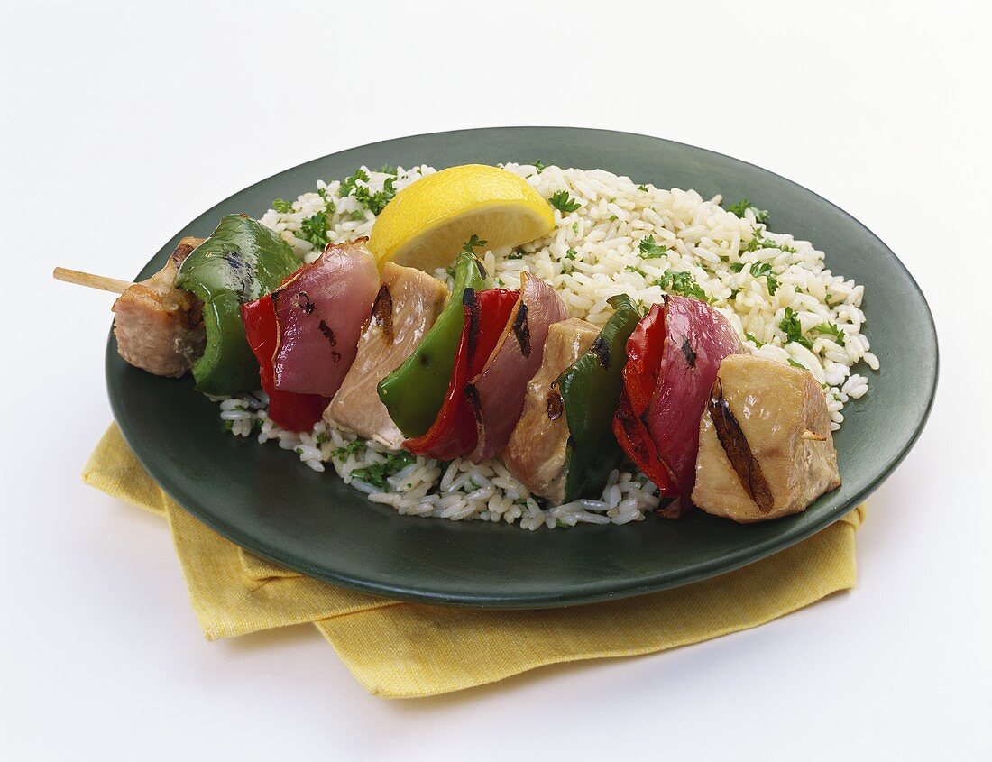 A Chicken Kabob with Bell Pepper and Red Onion Over White Rice