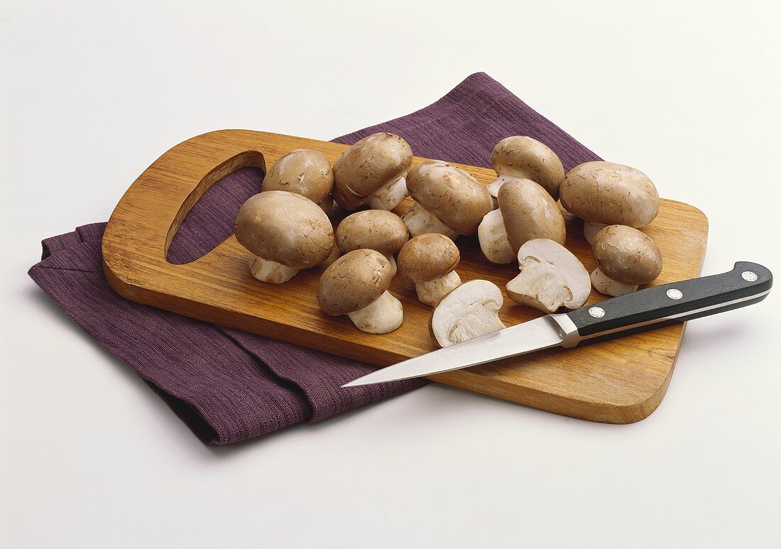 Cremini Mushrooms on a Wooden Board with Knife