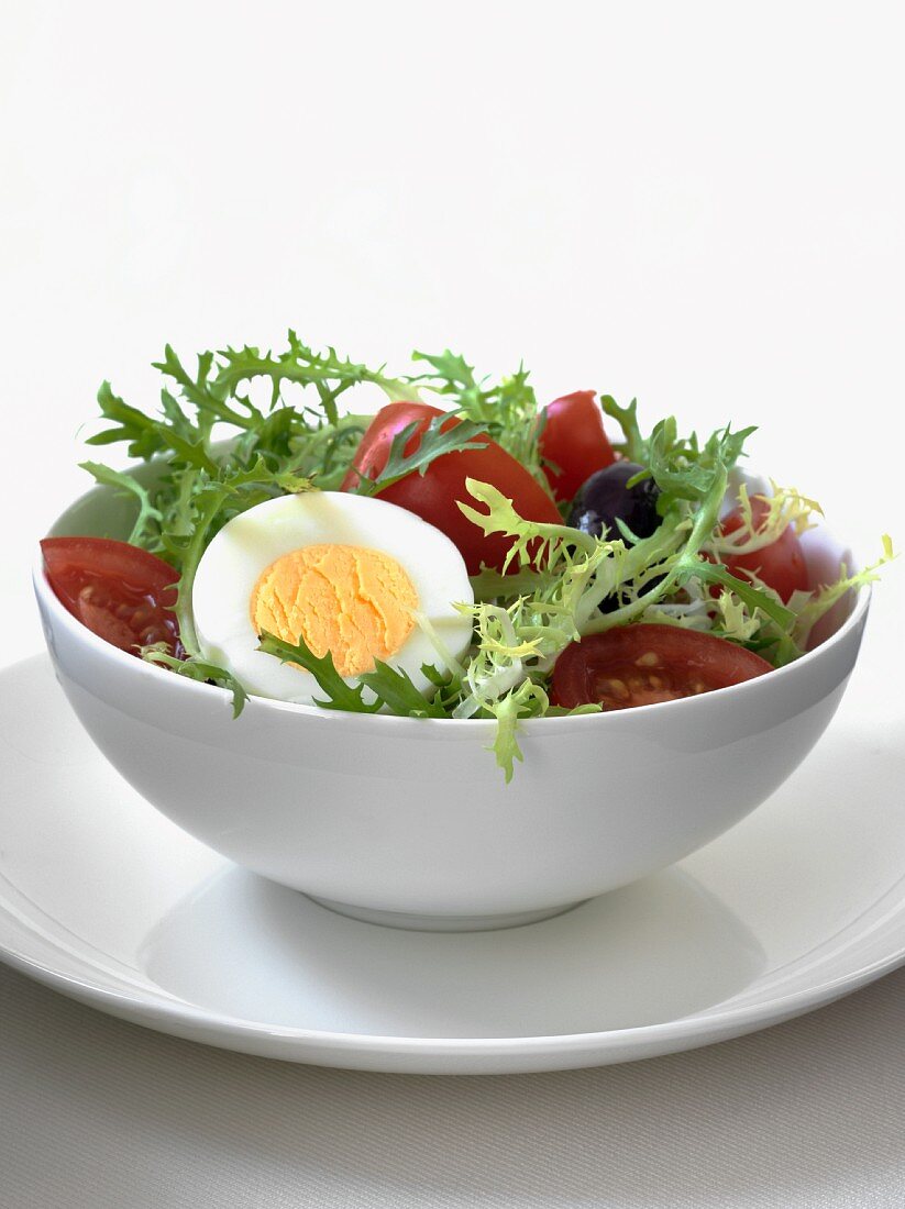 Friseesalat mit Tomaten, Oliven und hartgekochtem Ei