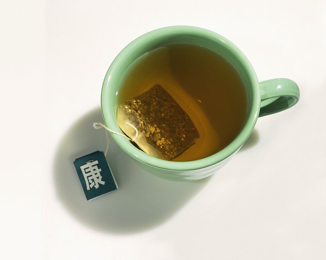 Cup of Green Tea with Tea Bag on a White Background