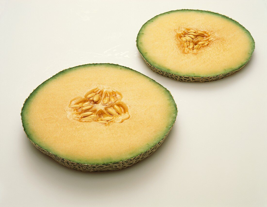 Two Slices of Cantaloupe on a White Background