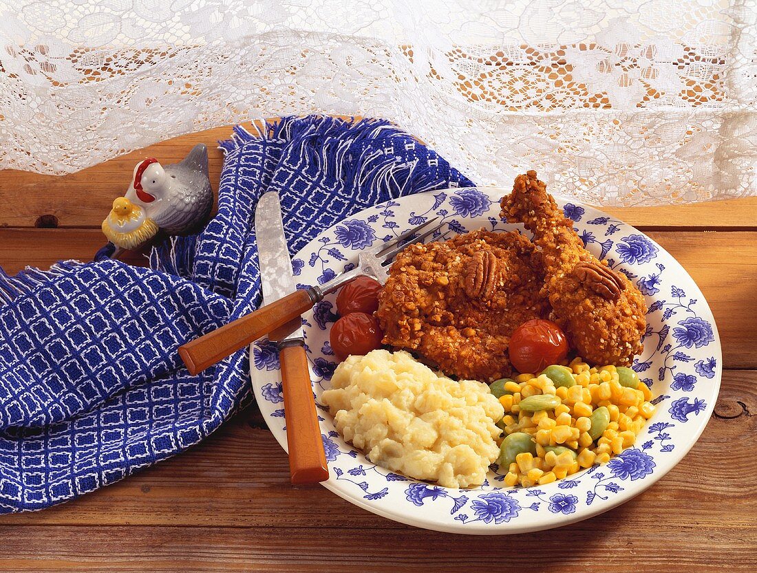 Pecan Fried Chicken on a Plate with Mashed Potatoes and Corn and Lima Bean Salad