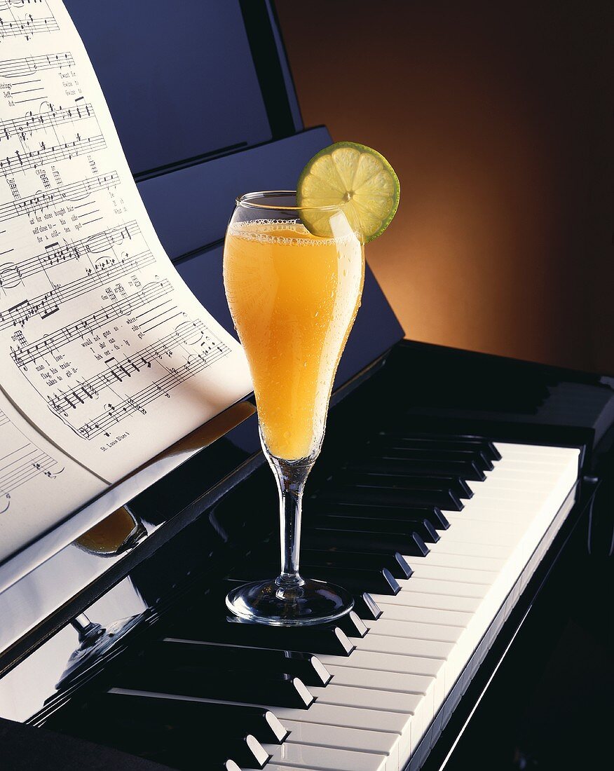 Orangendrink auf einem Piano