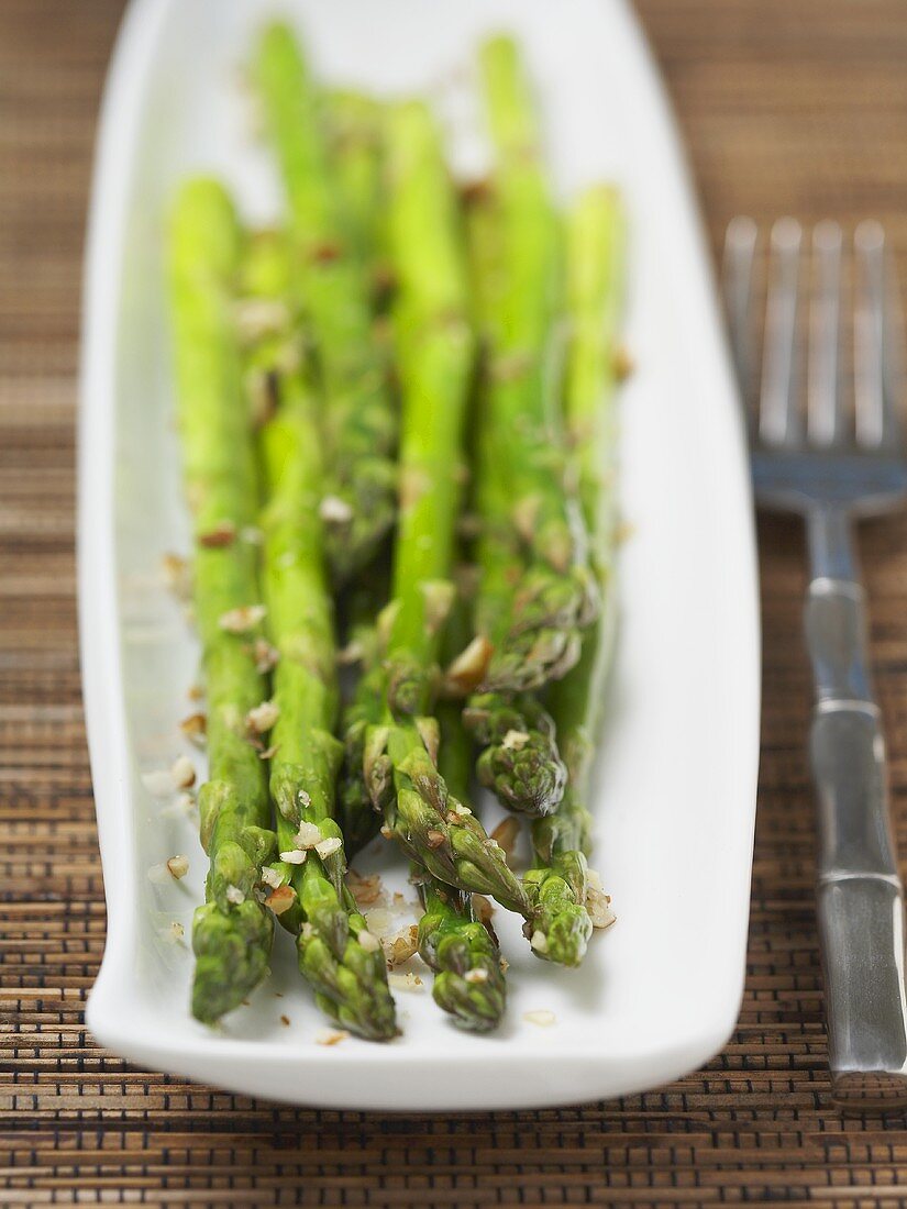 Grüner Spargel mit gehackten Walnüssen