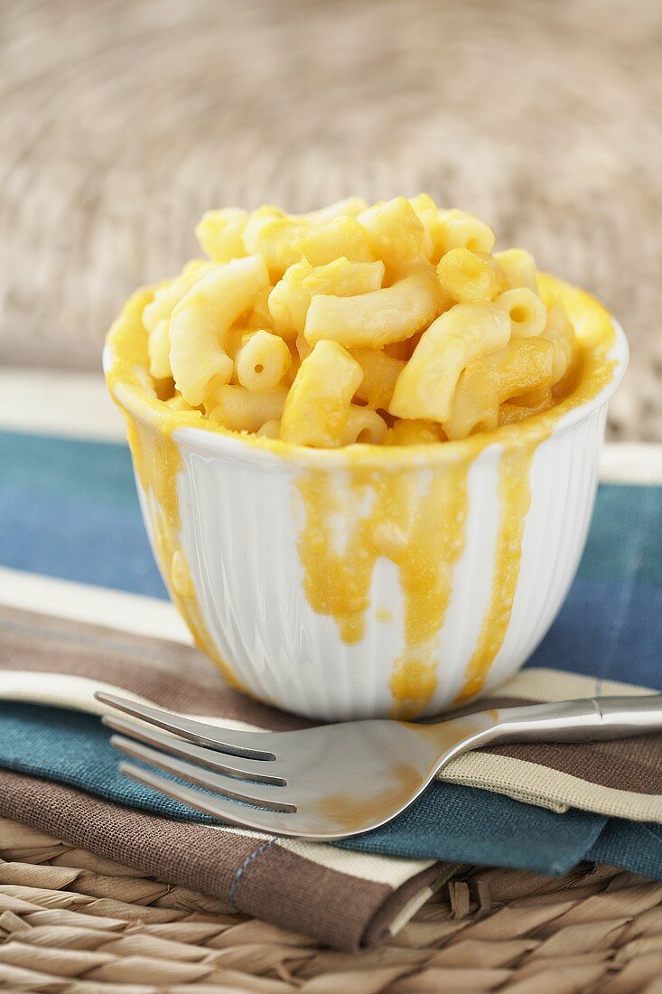 Small Bowl of Macaroni and Cheese with Cheese Dripping Down Sides of Bowl