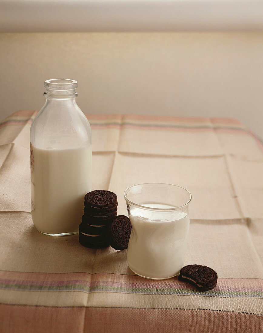 Glas und Flasche Milch mit Oreo Cookies