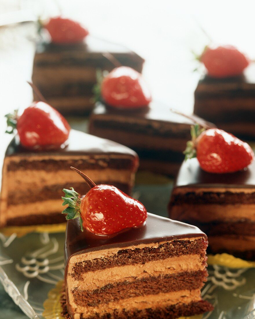 Slices of Layered Chocolate Mouse Torte Topped with Strawberries