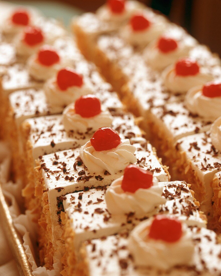 Rows of Torte Slices Topped with Maraschino Cherries
