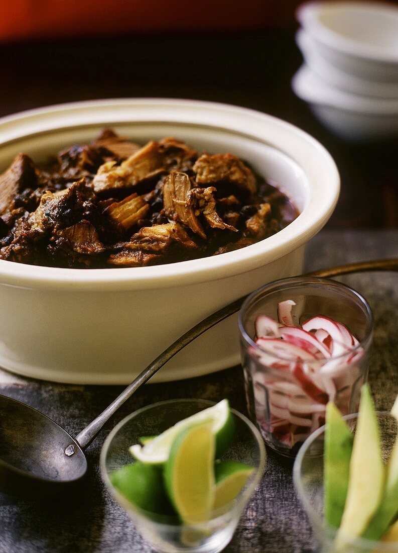 Pork Rib and Black Bean Chili in a Pot; Lime; Red Onion and Avocado