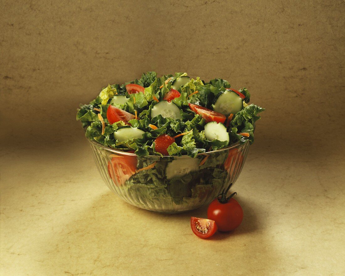 Gemischter Blattsalat mit Gurken und Tomaten in Glasschüssel