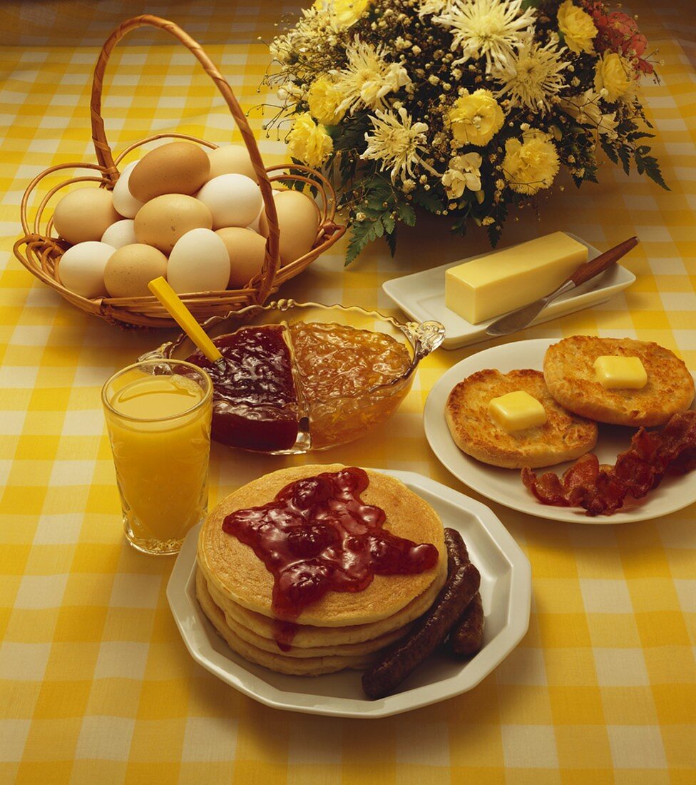 Frühstück mit Pancakes, Marmelade, Würstchen, Orangensaft