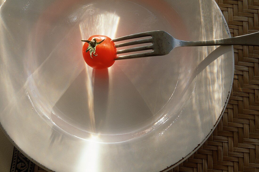 Fork Stabbing a Cherry Tomato on a Plate