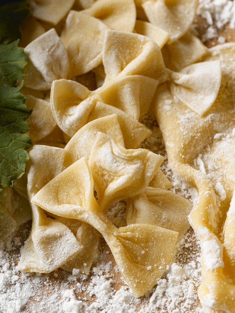 Selbstgemachte Farfalle mit Mehl auf Schneidebrett