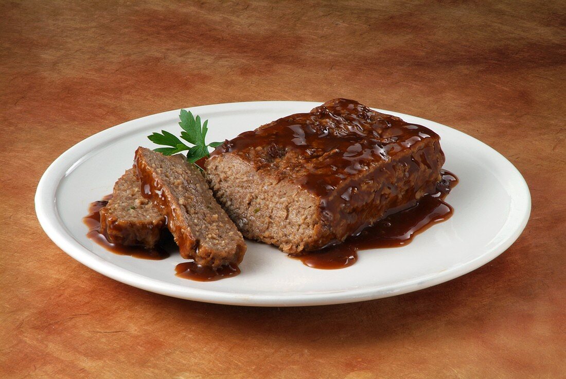 Partially Sliced Meatloaf with Gravy on a Plate