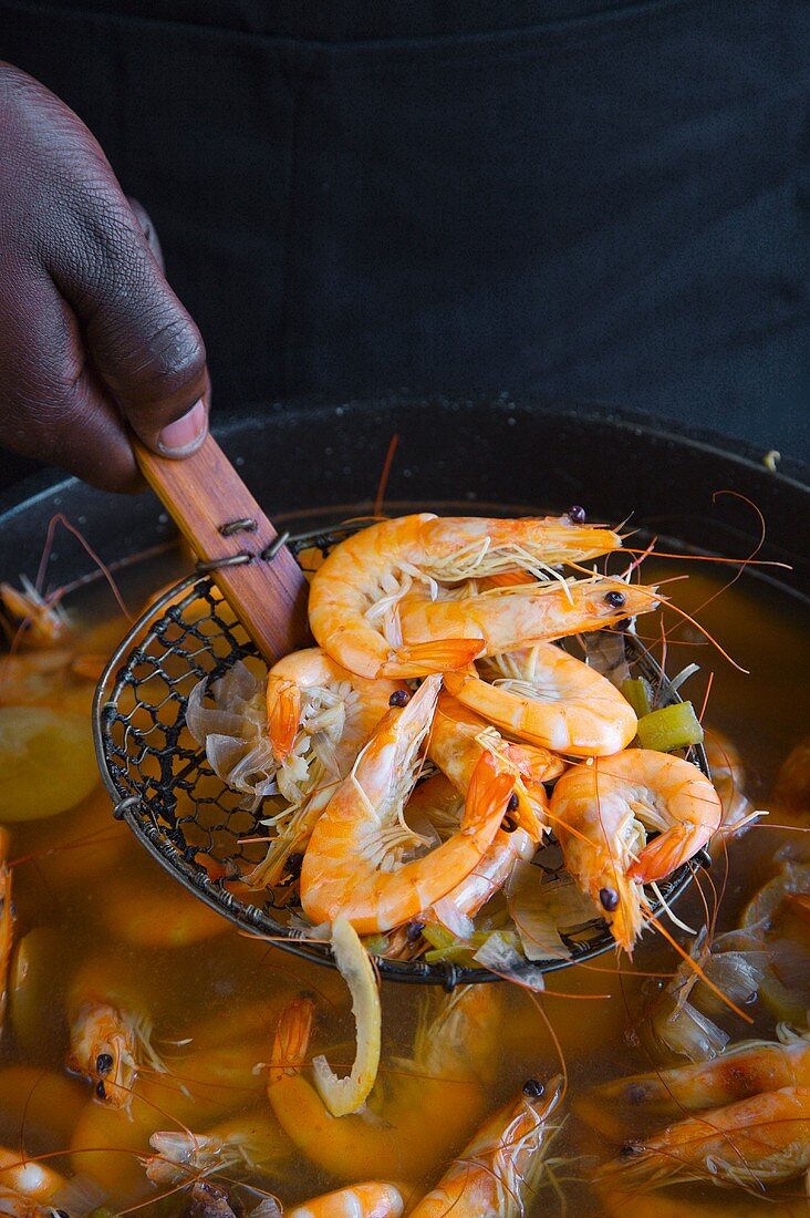 Scooping Whole Boiled Shrimp from a Pot of with Wire Scoop