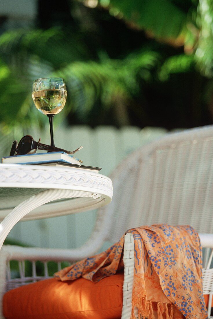 Glas Weißwein auf Gartentisch im Freien