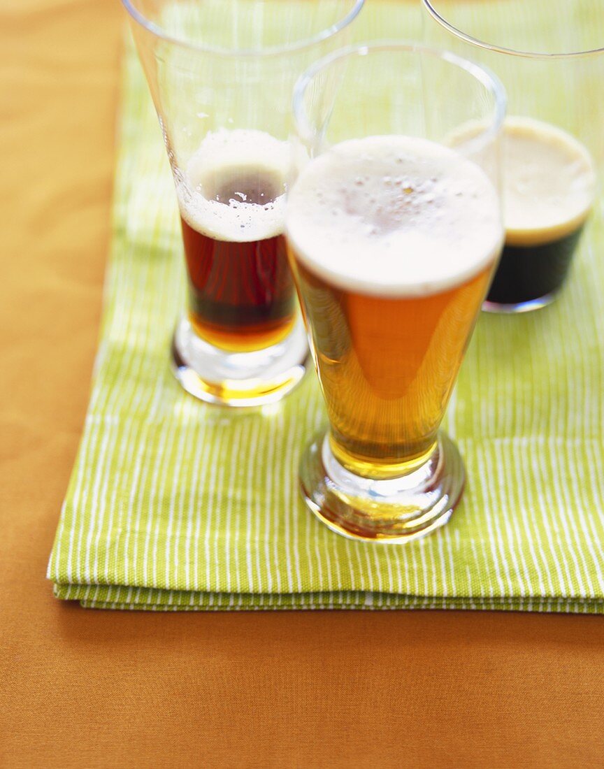 Drei Biersorten in Gläsern: helles und dunkles Ale und Stout