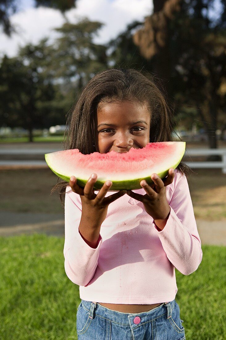 Young Girl Eating a Large Wedge of Watermelon
