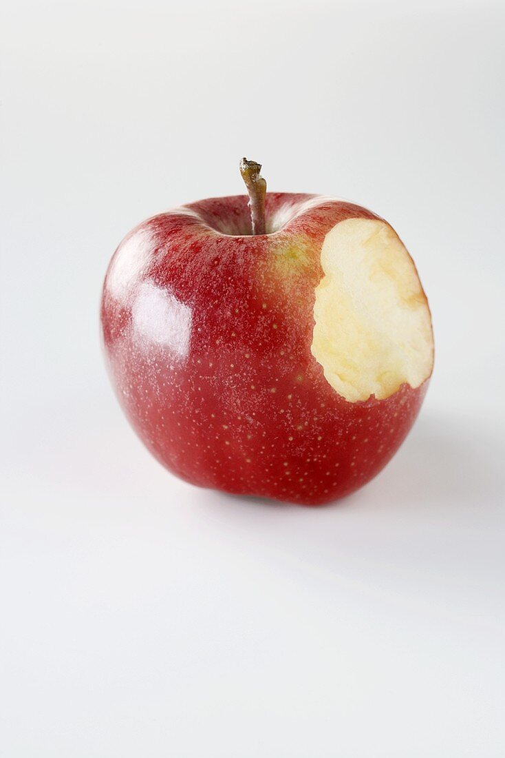 Ein glänzender roter Apfel, angebissen