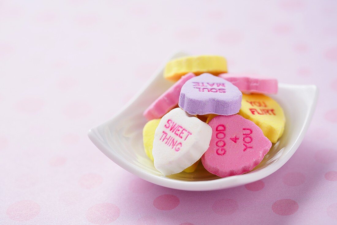 Zuckerherzen mit Aufschriften zum Valentinstag in Schale