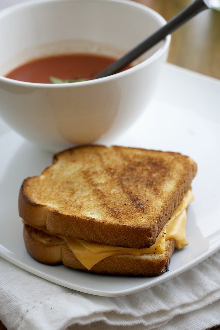 Käsetoast auf Teller mit Tomatensuppe in Schale