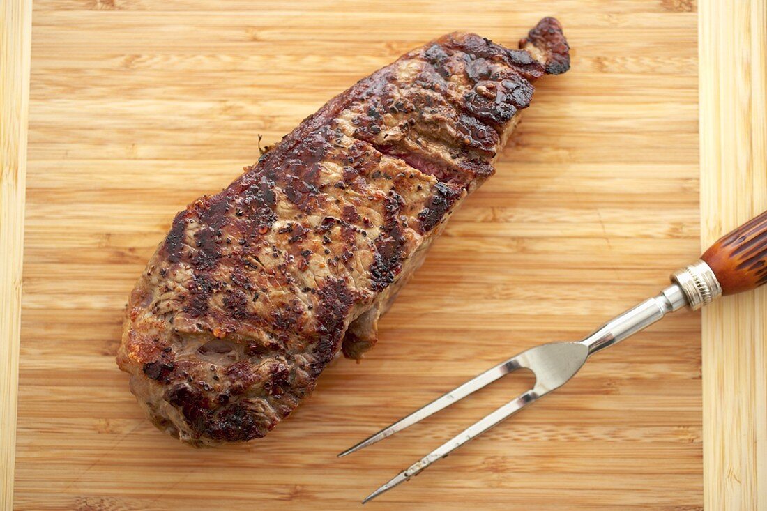 Gegrilltes Sirloin Steak auf Schneidebrett mit Fleischgabel