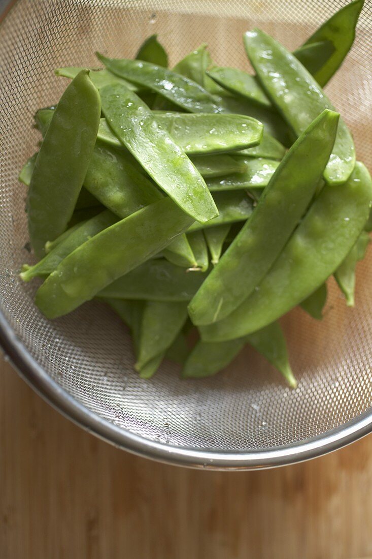 Freshly Washed Organic Snow Peas in a Strainer