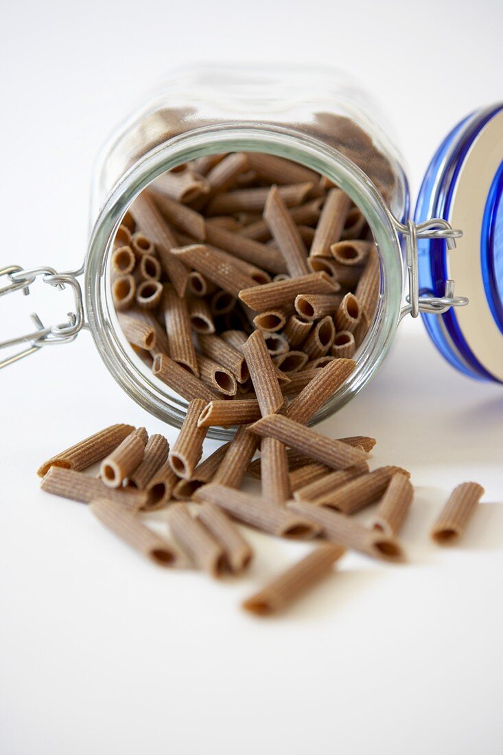 Whole Grain Penne Spilling from a Jar