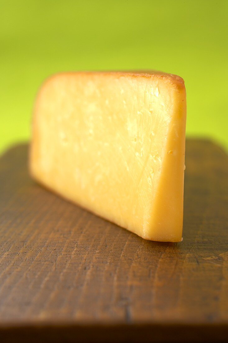 A Wedge of Smoked Gouda on a Wooden Board