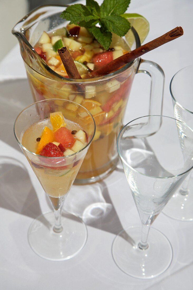 White Wine Sangria with Chopped Fruit in a Glass and Pitcher
