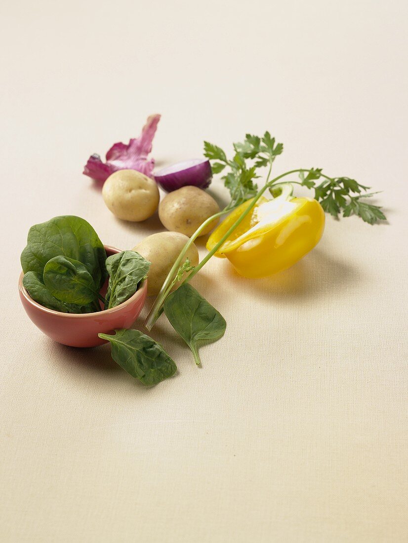 Gemüsestillleben mit Spinat, Paprika, Kartoffeln & Zwiebeln