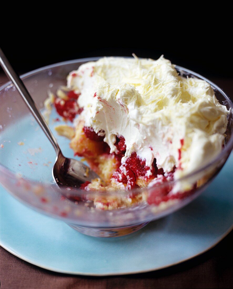 Layered dessert: sponge, raspberries, cream, white chocolate