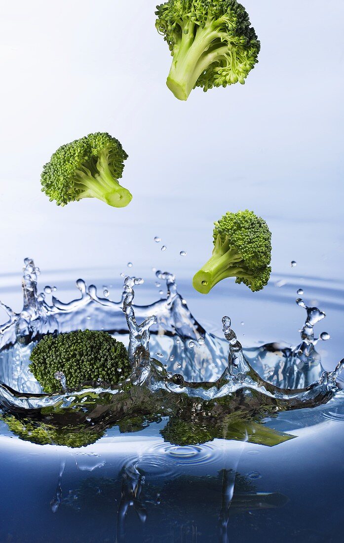 Broccoli florets falling into water