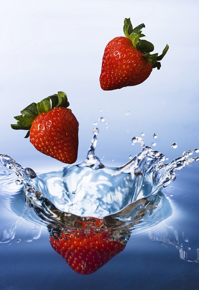 Strawberries falling into water