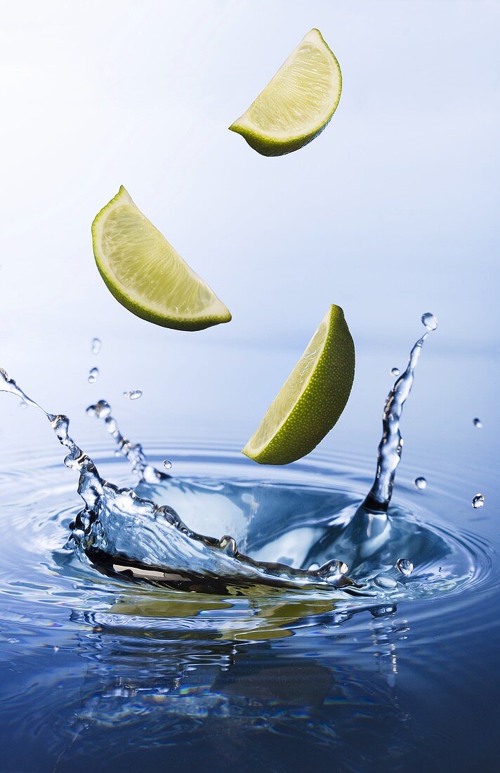 Lime slices falling into water