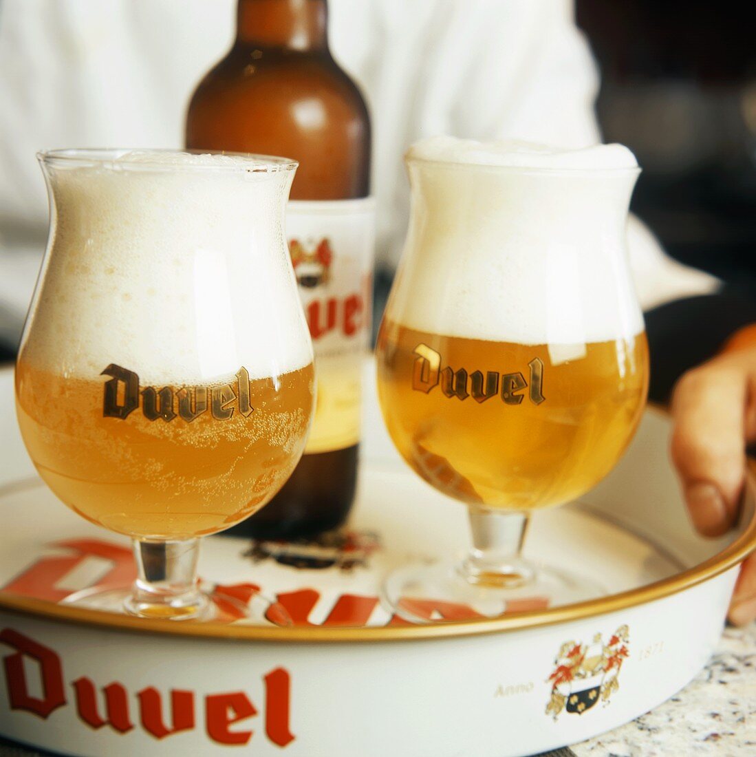 Kellner hält Tablett mit Duvel Bier in Gläsern & Flasche