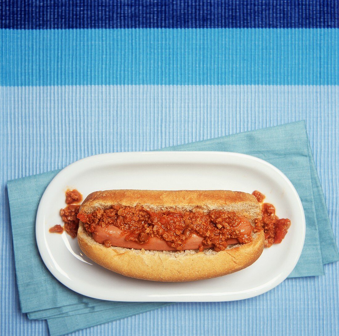 A Chili Dog on Blue from Overhead