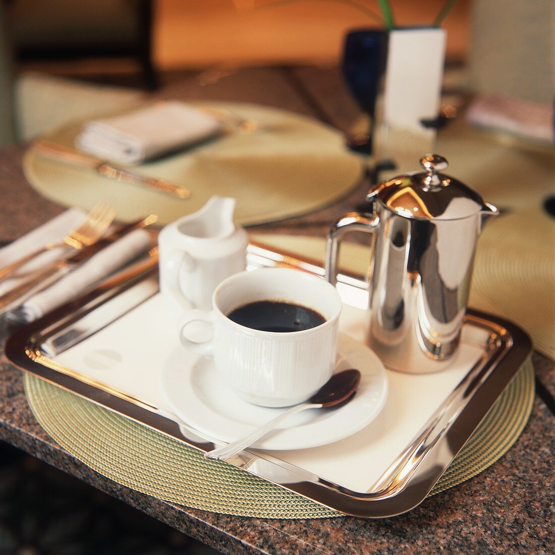 A Cup of Black Coffe on a Tray with Small Pot and Creamer