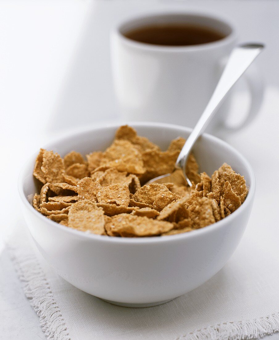 Eine Tasse Kaffee und eine Schüssel mit Cornflakes