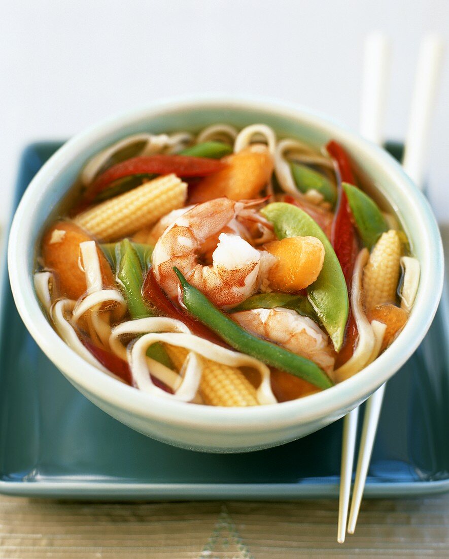 Asian noodle soup with shrimps and vegetables in small bowl