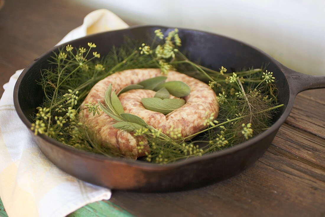 Raw sausage with sage and fennel in cast-iron frying pan