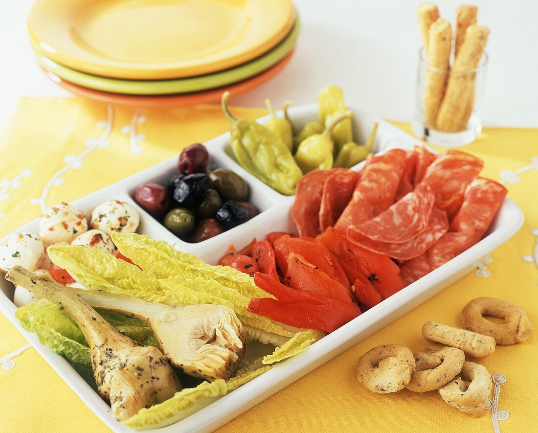 Antipasto in a Divided Dish; Serving Plates and Bread Sticks