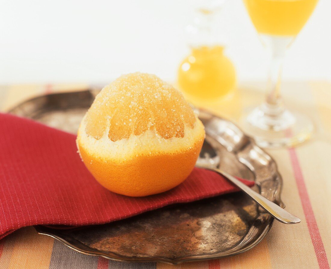 A sugared orange on a silver tray