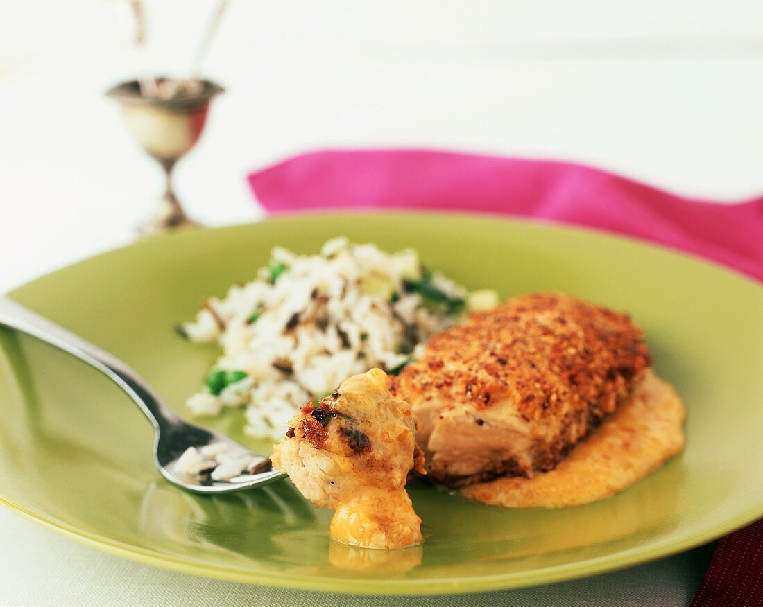 Pecan Crusted Chicken Breast with Apricot Curry Sauce and Rice; Piece of Chicken on Fork