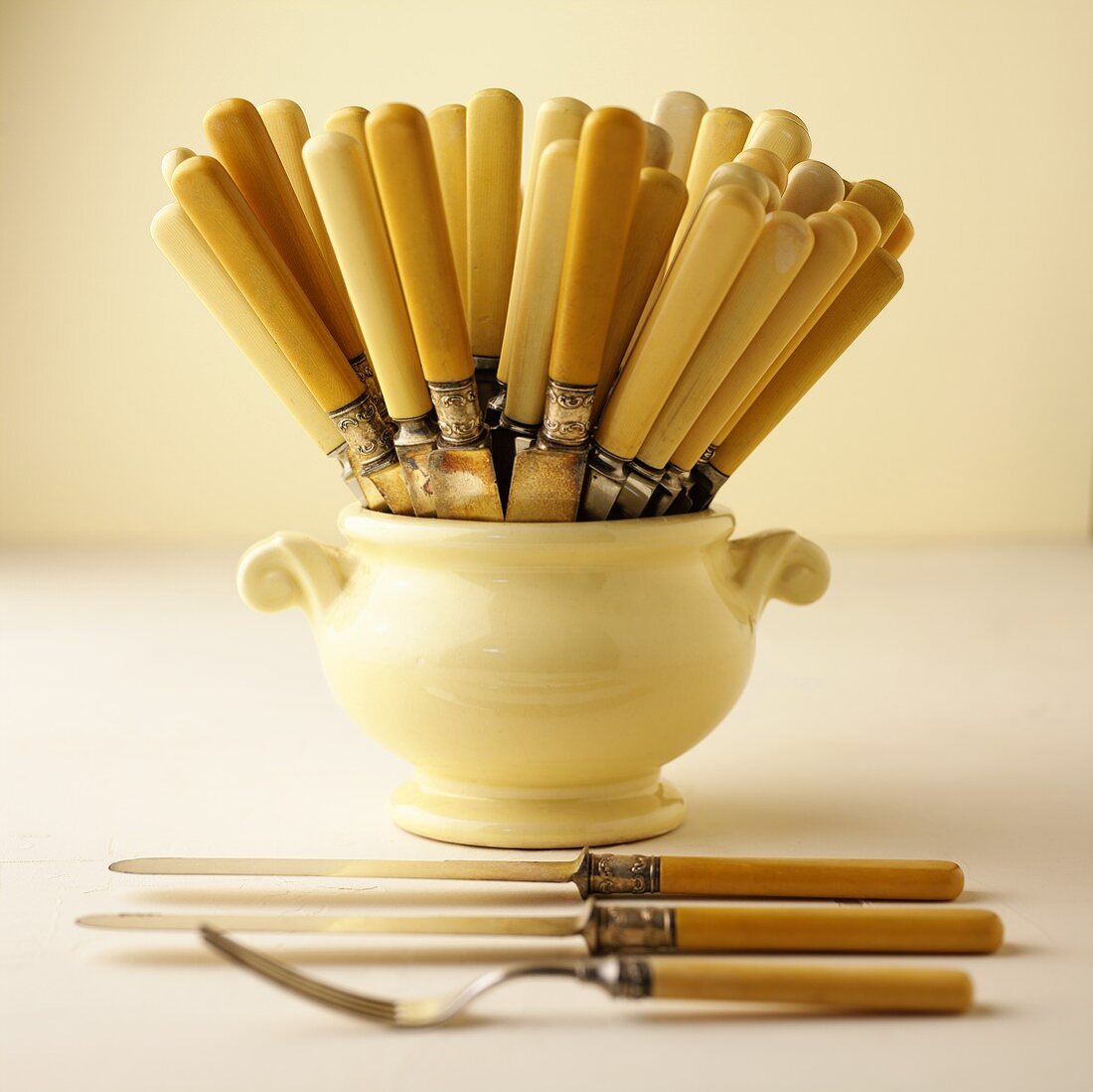 Knives in a vase; knife and fork in the foreground