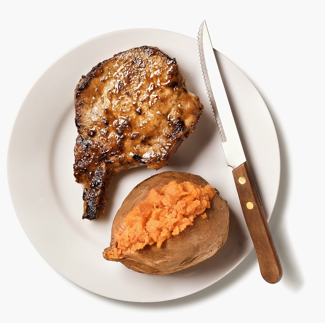 A Pan Fried Pork Chop with Sweet Potato and a Steak Knife