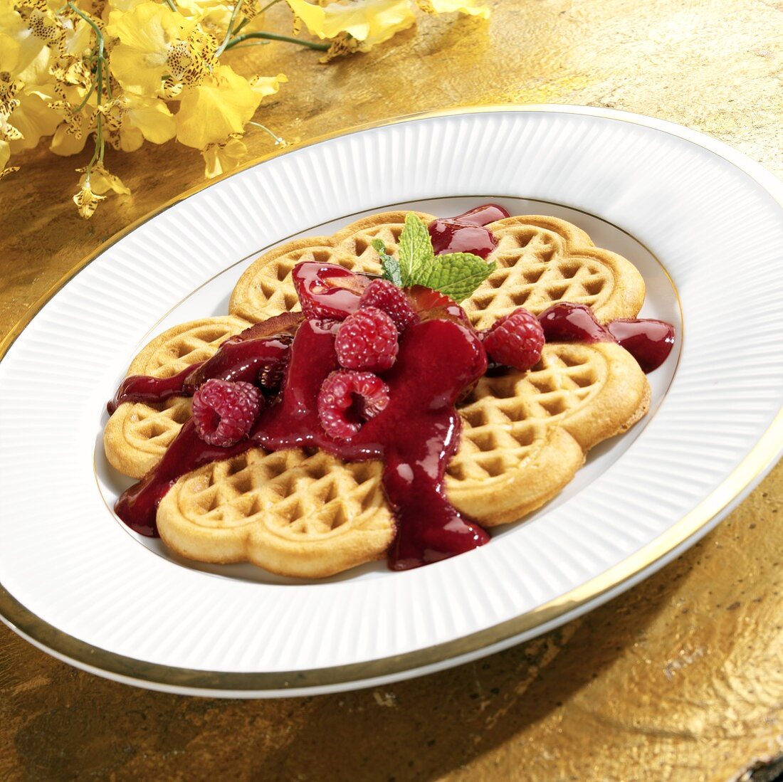 Heart-shaped waffles with berries and fruit sauce